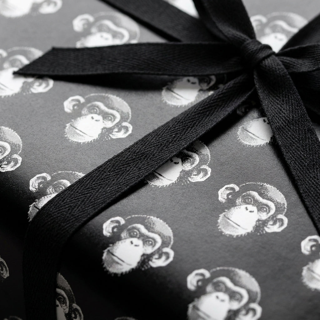 Black and white monkey wrapping paper with a textured black ribbon bow by Wrapped Studios.