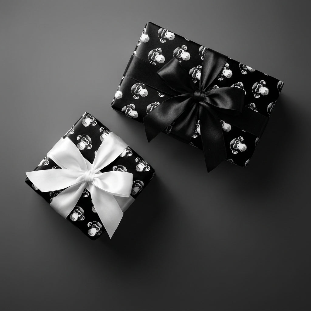 Playful black and white monkey wrapping paper on gift boxes with satin bows by Wrapped Studios.