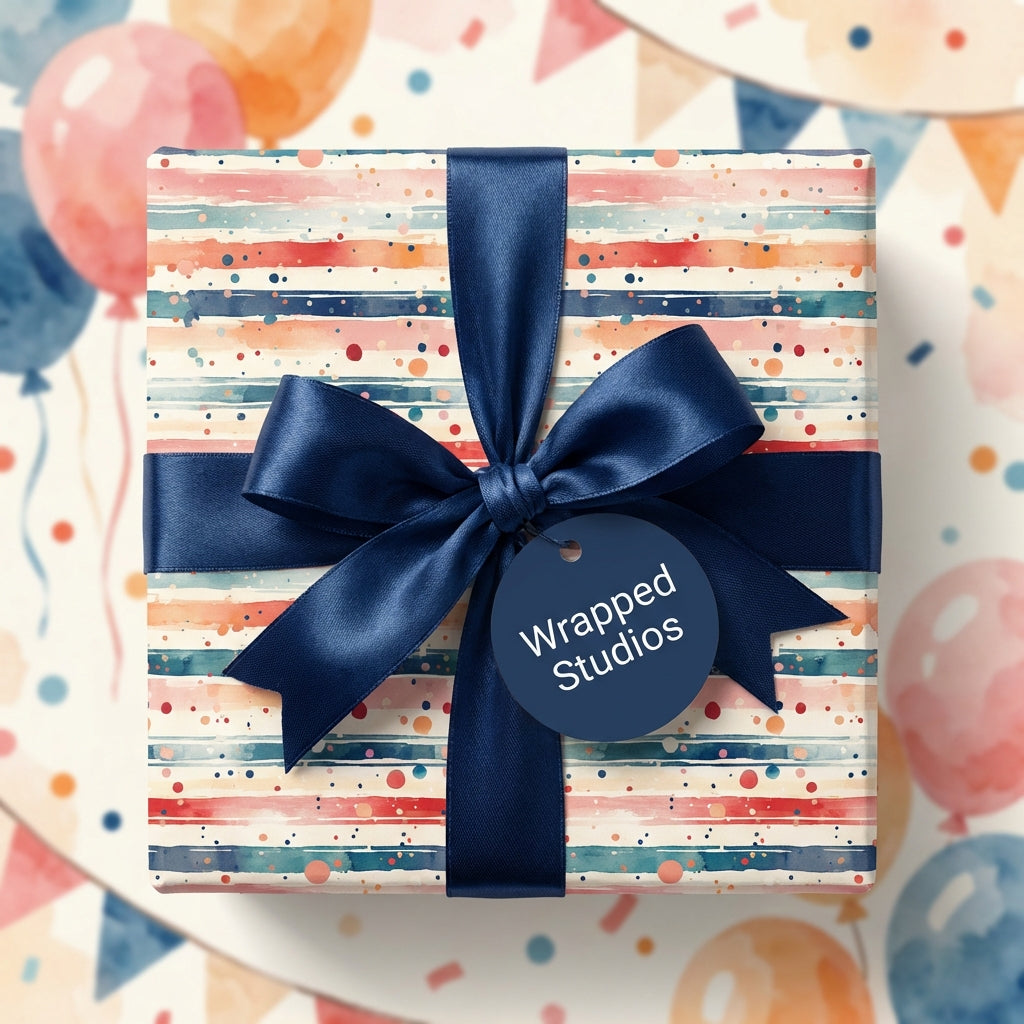 Striped birthday wrapping paper with watercolor accents and navy ribbon, Wrapped Studios.