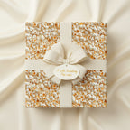 Square gift box wrapped in popcorn pattern wrapping paper with cream ribbon and tag.