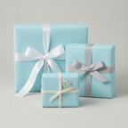 Light blue gift boxes wrapped in solid color wrapping paper with white, cream, and silver satin ribbons.