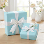 Light blue gift boxes wrapped in white ribbon, perfect for baby shower or elegant celebration wrapping paper.