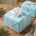 Light blue wrapping paper with a silver ribbon and bow on a gift box for Christmas or a birthday.