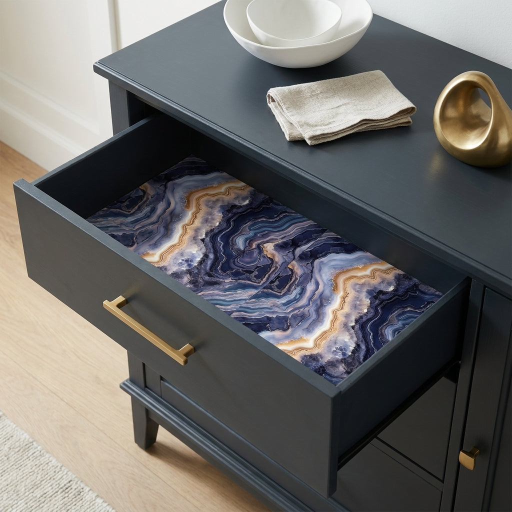 Luxury navy blue and gold agate wrapping paper by Wrapped Studios lining a dark dresser drawer.