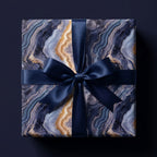 Luxury blue and gold agate wrapping paper with a navy satin bow by Wrapped Studios.
