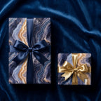 Luxury navy and gold marble wrapping paper on gifts with satin bows by Wrapped Studios.