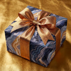 Blue agate marble luxury wrapping paper with a metallic gold bow by Wrapped Studios.