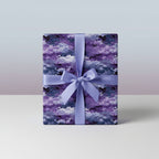 Purple and navy gift box wrapped in celestial watercolor pattern wrapping paper with matching ribbon.