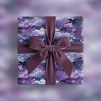 Elegant gift wrapped in purple watercolor wrapping paper with a velvet bow.