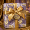 Luxury purple and gold marble wrapping paper with a satin gold bow, elegant gift wrap by Wrapped Studios.