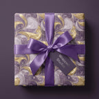 Luxury purple and gold marble wrapping paper with a matching satin ribbon bow by Wrapped Studios.