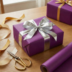 Elegant purple gift wrapping paper roll with silver ribbon and bow for birthdays or holidays.
