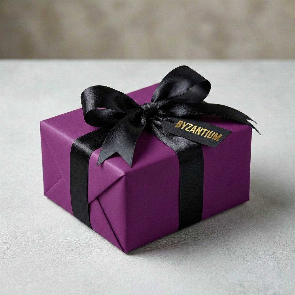 Elegant gift wrapped in solid purple wrapping paper with a black satin ribbon and bow.