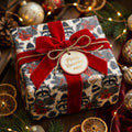 Cute raccoon Christmas wrapping paper with a red velvet bow and holiday gift tag by Wrapped Studios.
