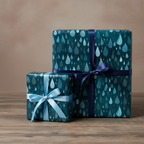 Teal wrapping paper with raindrop pattern and navy and light blue ribbon bows.