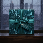 Elegant teal gift wrap with a raindrop pattern, tied with a satin bow, next to a rain-streaked window.