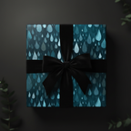 Teal gift box wrapped in modern raindrop wrapping paper with a black satin bow.