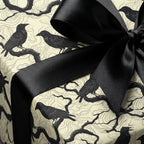 Elegant gift wrapped in bird & tree motif wrapping paper with black satin ribbon.