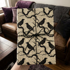 Raven-themed gift wrapped in decorative wrapping paper, tied with black string.
