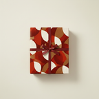 Gift box wrapped in modern geometric wrapping paper with a burgundy ribbon.