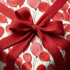 Red balloon birthday wrapping paper with rustic ribbon bow, Wrapped Studios.
