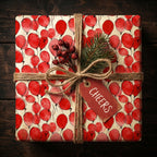 Festive red balloon wrapping paper with rustic twine, greenery and a "cheers" tag.