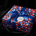 Red and blue camouflage wrapping paper with a blue satin bow by Wrapped Studios.