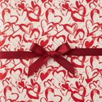 Red heart pattern wrapping paper with a burgundy satin bow, perfect for Valentine's Day or romantic gifts.