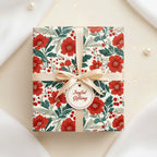 Square gift box wrapped in floral wrapping paper, tied with a cream ribbon and "Joyful Gifting" tag.