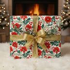 Elegant gift wrapped in floral Christmas wrapping paper with gold ribbon, near a fireplace.