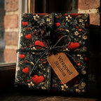 Vintage dark floral and red heart wrapping paper by Wrapped Studios on a gift box tied with twine.