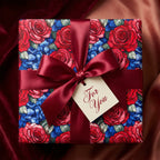 Elegant floral wrapping paper featuring red roses and hydrangeas with a deep red satin ribbon and gift tag.