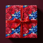 Elegant floral wrapping paper with red roses and blue hydrangeas, tied with a red satin ribbon.