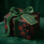 Elegant floral wrapping paper with red roses, dark background, and green velvet ribbon.