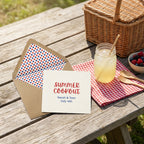 4th of July summer cookout invitation with polka dot envelope liner on a picnic table by Wrapped Studios.