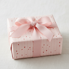Pink wrapping paper with red hearts and a matching pink ribbon bow, perfect for Valentine's Day or a romantic gift.