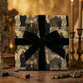 Religious gift wrap on gift box with black ribbon on a decorative background with candles and books.