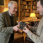 Man receiving gift wrapped in unique photo collage wrapping paper with black ribbon.
