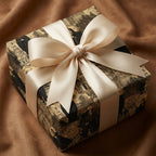 Elegant gift wrapped in ornate religious pattern paper with a luxurious ivory satin bow.