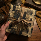 Hand holds square gift wrapped in historic religious figure pattern with bronze ribbon, vintage style.