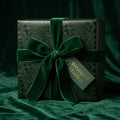 Wrapped Studios luxury gift wrap: Emerald green reptile print with velvet ribbon bow.