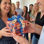 40th birthday wrapping paper on a gift given to a smiling woman at a party, by Wrapped Studios.