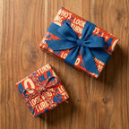 Retro 40th birthday wrapping paper on gift boxes with blue bow on wood, by Wrapped Studios.
