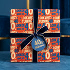 40th birthday wrapping paper with navy velvet bow and '40 & Fabulous' tag, by Wrapped Studios.