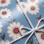 Vintage blue daisy floral wrapping paper tied with a white twine bow. Elegant gift wrap by Wrapped Studios.