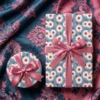 Luxury daisy floral wrapping paper on gift boxes with pink velvet bows by Wrapped Studios.