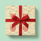 Popcorn wrapping paper with a red ribbon bow on a movie night gift box by Wrapped Studios.