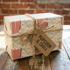 Retro popcorn wrapping paper with rustic twine and 'Popcorn & Chill' tag by Wrapped Studios.