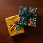 Two wrapped gifts: one gold with a gold ribbon, one with retro circle print wrapping paper and a green velvet ribbon.