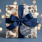 Steampunk wrapping paper with a robot and gear pattern, tied with a navy ribbon. By Wrapped Studios.